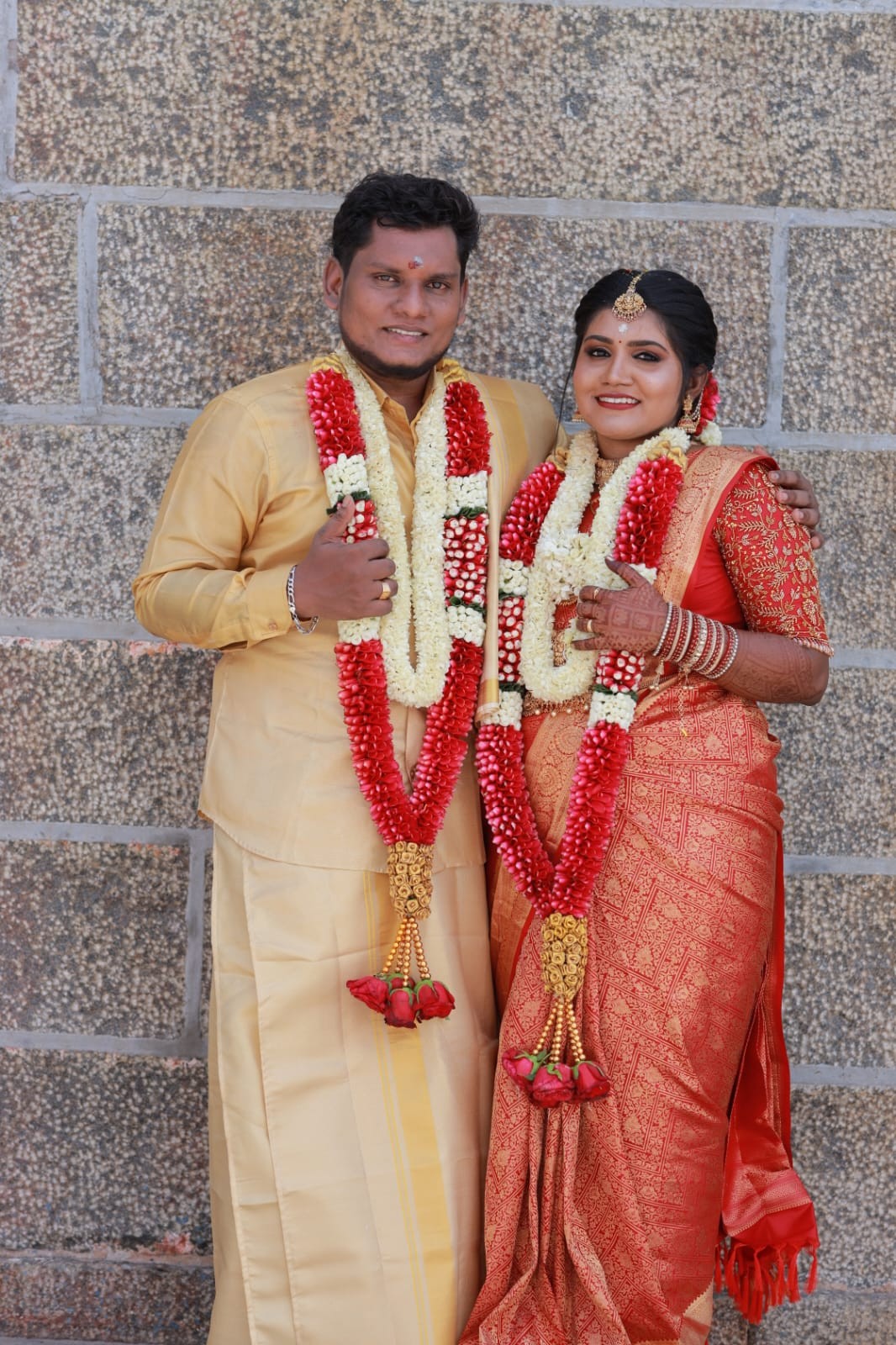 Couple wearing traditional Arumugam Flowers wedding garlands